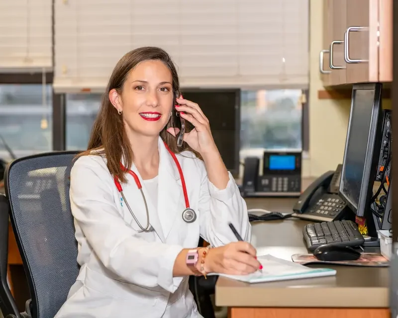 Dr. Kerrie Lewis on a phone consultation with a referring veterinarian at her desk