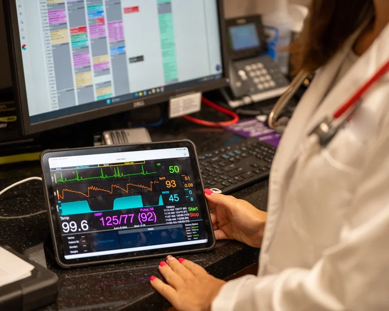 Dr. Kerrie Lewis reviewing real-time anesthesia monitoring data on a tablet during a virtual consult